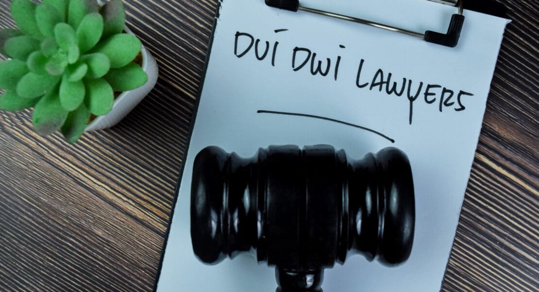 Concept of Dui Dwi Lawyers write on paperwork with gavel isolated on Wooden Table.