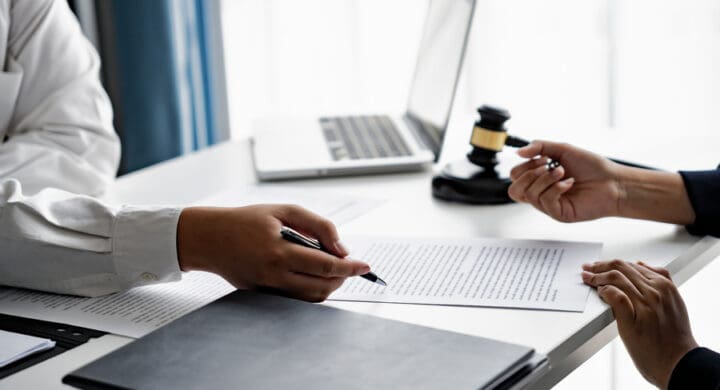 serious courtroom lawyer preparing personal injury claim documents for business client before official hearing