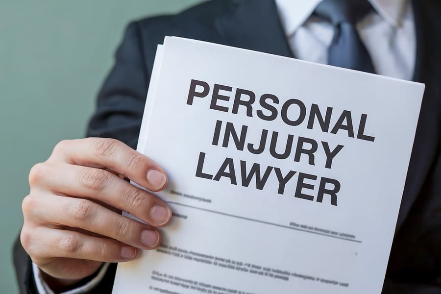A lawyer in a suit holds a document that says personal injury lawyer in large, bold letters, offering legal representation for victims