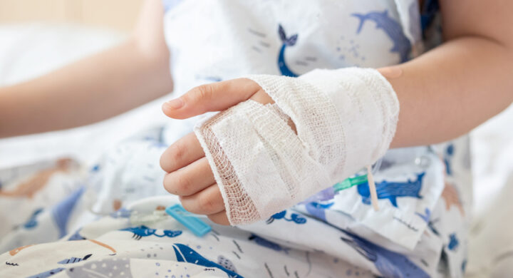 Close up child hand with saline IV solution in hospital injured in accident