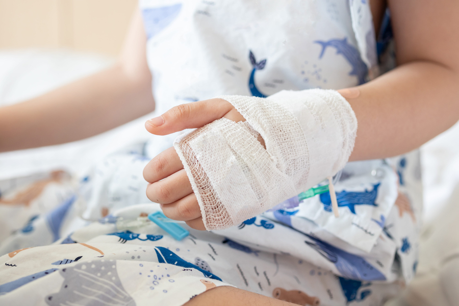 Close up child hand with saline IV solution in hospital injured in accident