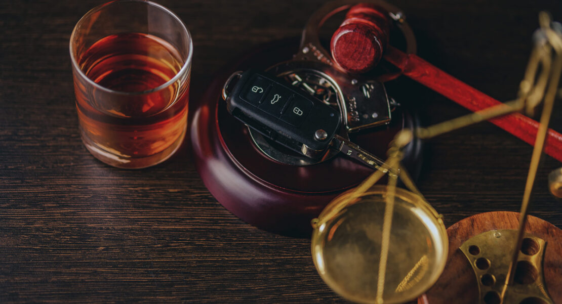 Whiskey with car keys and handcuffs. Concept for drinking and driving