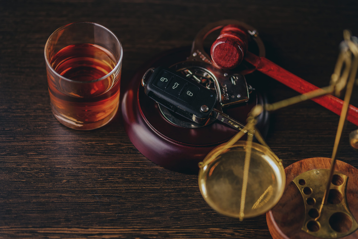 Whiskey with car keys and handcuffs. Concept for drinking and driving